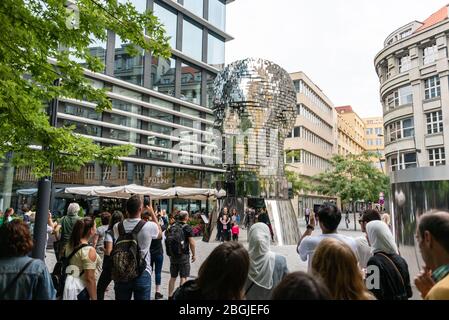 Les gens, touristes regardant le chef de Franz Kafka connu sous le nom de Statue de Kafka sculpture extérieure par David Cerny, installé à l'extérieur des magasins Quadrio Banque D'Images