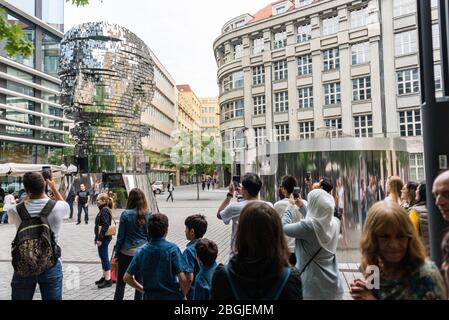 Les gens, touristes regardant le chef de Franz Kafka connu sous le nom de Statue de Kafka sculpture extérieure par David Cerny, installé à l'extérieur des magasins Quadrio Banque D'Images