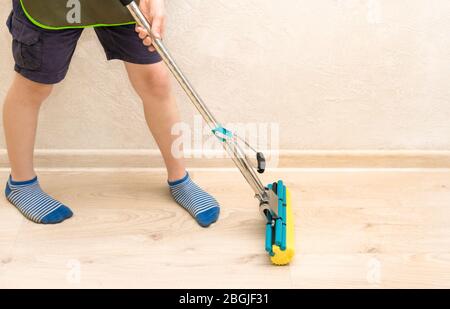 Nettoyage de la maison pendant la période de quarantaine. Aidez les enfants à nettoyer l'appartement, à la maison. Banque D'Images