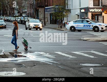 Une femme qui descend la première Avenue à New York pendant la pandémie de la VID19 avril 2020. Banque D'Images