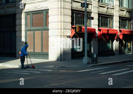 Une personne qui balaie à Soho pendant la pandémie de COVID 19 à New York. Avril 2020. Banque D'Images