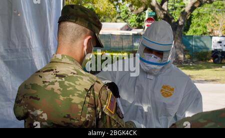 La Garde nationale de Floride SPC. Joshua Henderson, un médaillé de combat, recueille un échantillon d'un patient dans les sites d'essai communautaires près du parc Marlins, le 25 mars 2020. Marlins Park sera un comté géré CBT soutenu par le FLNG et d'autres organismes d'État. Banque D'Images