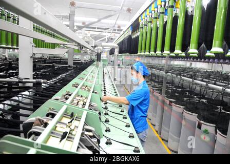 Le personnel de l'usine de filature Tianhong, une usine locale qui permet une reprise complète de la production, travaille sur une chaîne de production automatisée, comté de Suining, Xuzhh Banque D'Images