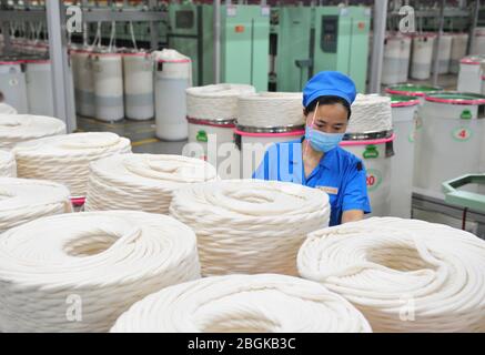 Le personnel de l'usine de filature Tianhong, une usine locale qui permet une reprise complète de la production, travaille sur une chaîne de production automatisée, comté de Suining, Xuzhh Banque D'Images