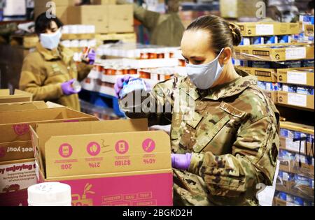 Airman 1ère classe Alicia Day, une exploitation de système Cyber avec le 194ème Escadron de renseignement, emballe une boîte avec des aliments en conserve à la banque alimentaire nourrissant de Lakewood, Washington, le 3 avril 2020. Jour, un résident de Tacoma est un spécialiste de la garde d'enfants des Centres de développement de l'enfant sur la base commune Lewis - McChord, Washington. Les membres de la Garde nationale de l'Air et de l'Armée de terre de Washington soutiennent les banques alimentaires autour de l'État pendant la riposte à la pandémie de COVID-19. (ÉTATS-UNIS Photo de la Garde nationale par Joseph Siemandel) Banque D'Images