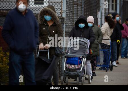 Chelsea, Massachusetts, États-Unis. 21 avril 2020. Les résidents attendent en ligne pour récupérer des boîtes à nourriture et des repas chauds. Le COVID-19, le virus Corona, situation à Chelsea, Massachusetts est un point chaud majeur. Chelsea est la ville la plus durement touchée de l'État. Chelsea est une population immigrée d'Amérique latine lourde, 80% de la population étant des travailleurs essentiels, comme les commis d'épicerie. Avec des emplois perdus, les gens ont du mal à pouvoir obtenir de la nourriture. L'Armée du Salut donne des boîtes de nourriture et des repas chauds tous les jours. Les lignes sont ratées pour les rues de la ville pour trouver des boîtes de nourriture. Crédit: Allison Dinner/ZUMA Wire/Alay Live News Banque D'Images