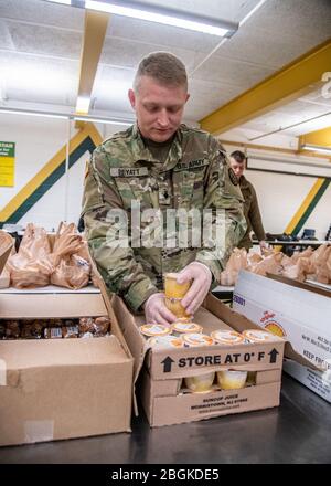 SPC. Carl Peyatt III, membre de C Battery, 1ère Bataillon, 201ème Régiment d'artillerie de campagne de la Garde nationale de Virginie-Occidentale, aide les bénévoles du Comité de rétablissement à long terme du Grand Greenbrier à préparer des repas pour plus de 3 600 élèves d'âge scolaire dans tout le comté de Greenbrier, en Virginie-Occidentale, pendant l'éclosion de pandémie de COVID-19, 25 mars 2020, à Lewisburg, en Virginie occidentale. Les soldats de la WVNG ont soutenu plus de 30 bénévoles dans l'emballage et la livraison des repas aux enfants nécessiteux dans le comté et continueront de le faire pendant la durée de l'éclosion. (ÉTATS-UNIS Garde nationale de l'armée Banque D'Images