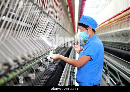 Le personnel de l'usine de filature Tianhong, une usine locale qui permet une reprise complète de la production, travaille sur une chaîne de production automatisée, comté de Suining, Xuzhh Banque D'Images