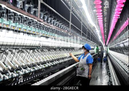 Le personnel de l'usine de filature Tianhong, une usine locale qui permet une reprise complète de la production, travaille sur une chaîne de production automatisée, comté de Suining, Xuzhh Banque D'Images