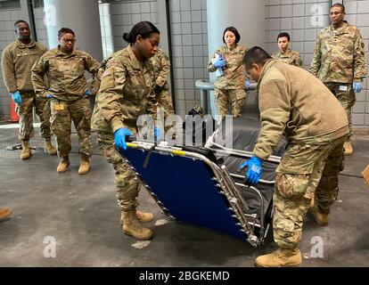 Les soldats de la Garde nationale de l'Armée de New York de la 133ème compagnie d'approvisionnement composite, qui fait partie du 53ème Commandement de la Troop, démontrent l'assemblage d'un lit bébé au Centre de congrès Jacob K. Javits de New York le 26 mars 2020. Le centre des congrès sera un autre centre de soins pour réduire la pénurie de lits dans les hôpitaux de New York dans le cadre de la réponse de l'État à l'épidémie COVID-19 (États-Unis Photo de la Garde nationale aérienne par Sean Madden, homme principal) Banque D'Images