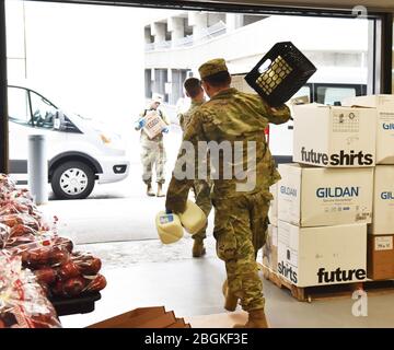 Les soldats de la Garde nationale de l'armée de New York chargent des approvisionnements alimentaires dans des véhicules au Times Union Center d'Albany, dans l'État de New York, le 31 mars 2020, pour livraison aux résidents du comté d'Albany qui sont en quarantaine. La Garde nationale de New York a mobilisé plus de 2 700 soldats et aviateurs dans le cadre de la réaction de l'État à la pandémie de COVID-19. ( photo de la Garde nationale aérienne américaine par le Sgt principal. William Gizara) Banque D'Images