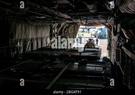 Un équipage d'aéronef Hercules C-130 H avec le 169ème Escadron de transport aérien de la Garde nationale aérienne de l'Illinois charge des gousses d'isolement médical sur leur avion à Eugene, Oregon, le 8 avril 2020. Deux avions de l'aile C-130 S de 182ème ont transporté 250 isolations dans un centre médical alternatif de McCormick place pendant la nuit à l'aéroport international Midway de Chicago, pour la mission de défense de la patrie, dans le cadre de la lutte contre la pandémie COVID-19. (ÉTATS-UNIS Photo de la Garde nationale aérienne par Tech. Sgt. Lealan Buehrer) Banque D'Images