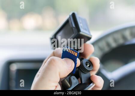 La main d'un conducteur de voiture de mâles qui détient une voiture DVR enregistrement des incidents et une carte mémoire pour elle Banque D'Images