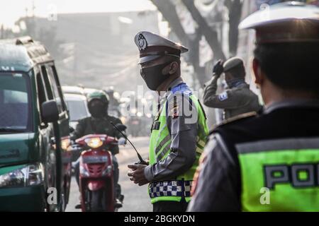 Bandung, Indonésie. 22 avril 2020. Les policiers indonésiens contrôlent le trafic pendant la mise en œuvre des restrictions sociales à grande échelle à un point de contrôle à Cibiru Bandung. Les restrictions sociales à grande échelle (PSBB) dans la ville de Bandung, de Cimahi et de Sumedang Regency, West Java sont entrées en vigueur aujourd'hui jusqu'au 5 mai 2020 pour endiguer la large propagation de COVID-19. Crédit: SOPA Images Limited/Alay Live News Banque D'Images