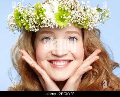 Bonne jeune fille aux yeux bleus avec couronne de fleurs Banque D'Images