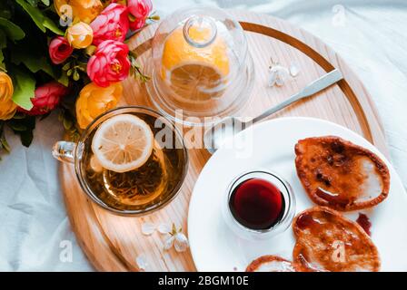 Petit déjeuner au lit. Nourriture dans le lit. Pour rester à la maison. Crêpes et thé. Placer pour le texte. Pose plate Banque D'Images
