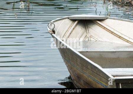 Bateau à rangées d'aluminium ou d'aluminium près de l'eau, du lac, de la rivière avec des ondulations et des roseaux à gazon concept été amusement, loisirs et activité de loisirs Banque D'Images