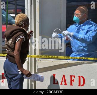 Une femme administre un kit d'auto-test COVID-19 dans un poste d'essai local DE LA Fire Department, où les travailleurs des combinaisons hazmat ont remis des écouvillons d'essai aux sans-abri depuis derrière une fenêtre de protection dans la section de la ligne de protection de Los Angeles le mardi 21 avril 2020. Quarante-trois autres personnes ont fait des tests positifs pour le coronavirus à la Mission de sauvetage de l'Union, le plus ancien et le plus grand abri de Los Angeles. La flambée soudaine dans les cas vient malgré les précautions extrêmes que le refuge a prises pour empêcher une telle éclosion. Photo de Jim Ruymen/UPI Banque D'Images