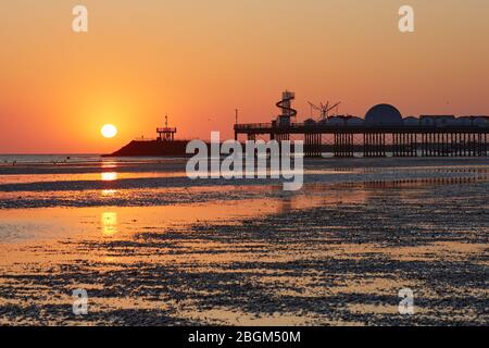 Herne Bay, Kent, Royaume-Uni. 22 avril 2020: Météo britannique. Lever du soleil à l'embarcadère de Herne Bay dans le Kent le jour de la Terre comme le temps continue d'être chaud et sec mais avec une brise ne fraîche. Le COVID 19 se maintient alors que la jetée et le squelette d'hélices et d'autres divertissements sont fermés au public. On demande aux gens de revenir loin des plages ce week-end. Crédit: Alan Payton/Alay Live News Banque D'Images