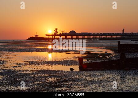 Herne Bay, Kent, Royaume-Uni. 22 avril 2020: Météo britannique. Lever du soleil à l'embarcadère de Herne Bay dans le Kent le jour de la Terre comme le temps continue d'être chaud et sec mais avec une brise ne fraîche. Le COVID 19 se maintient alors que la jetée et le squelette d'hélices et d'autres divertissements sont fermés au public. On demande aux gens de revenir loin des plages ce week-end. Crédit: Alan Payton/Alay Live News Banque D'Images