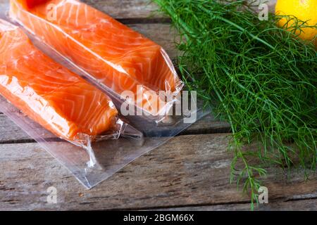 Filets de saumon à base de poisson rouge sur table en bois. Poisson frais, citron et aneth pour la cuisson des ingrédients. Oméga-3. Mise au point sélective Banque D'Images