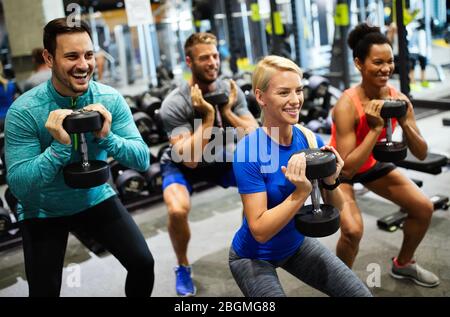 Groupe d'amis souriant et profiter du sport dans la salle de gym Banque D'Images