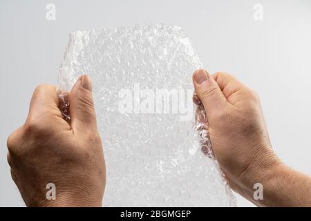 une feuille de rembourrage en plastique à bulles entre vos mains Banque D'Images