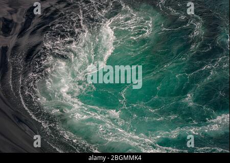 Le noir et le turquoise de l'eau tourbillonnante du maelström Saltstraumen à Bodo, Norvège. Saltstraumen a un des plus forts courants de marée dans le monde Banque D'Images