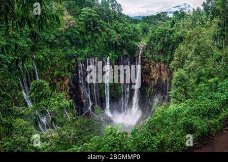 Panorama de la chute d'eau de Tumpak Sewu et du volcan Semeru dans les nuages depuis la pente orientale. Banque D'Images