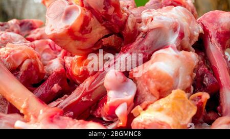 De nombreux os de poulet à craie crues hachés dans le tas se trouvent sur la table. Manger des pauvres ou manger pour les chiens. Mise au point sélective. Gros plan. Éclairage naturel. Banque D'Images