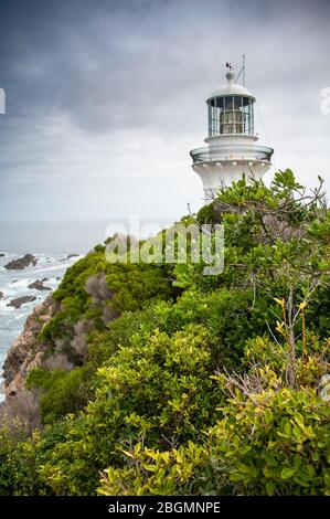 Le phare de Sugarloaf à Seal Rocks, Myall Lakes National Park, NSW, Australie. Phare sur colline, grosse mer et ciel nuage gris Banque D'Images