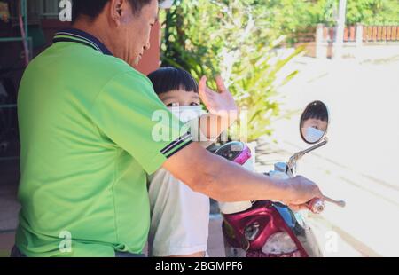 Grand-père a pris petit-fils aller sur le marché et porter une protection blanche masque pour protéger le coronavirus ( covid-19 ) Banque D'Images