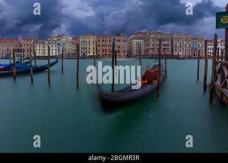 Les gondoles vénitiennes sont ancholoses dans le Canal Grande, derrière les maisons et les palazzi, l'atmosphère d'orage, Venise, Vénétie, Italie Banque D'Images