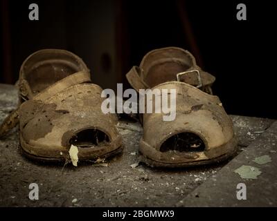 Des chaussures pour enfants sont laissées à la maternelle dans la ville fantôme Pripyat, zone d'exclusion de Tchernobyl, Ukraine. Banque D'Images