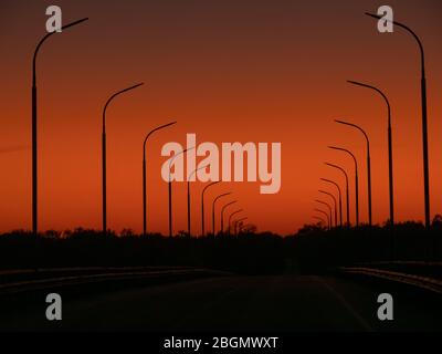 Coucher de soleil sur le vieux pont de la zone d'exclusion de Tchernobyl. De ce pont, les habitants de Pripyat ont assisté à la catastrophe dans la centrale électrique. Banque D'Images