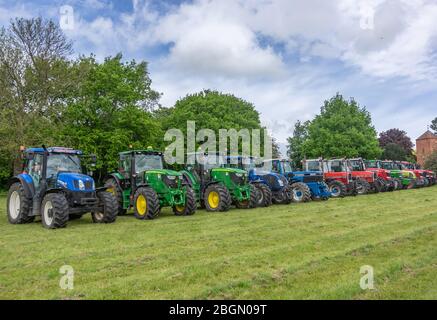 Pocklington, Yorkshire, Royaume-Uni, 24/05/2015 - une gamme de tracteurs multicolores stationnés dans un champ. Banque D'Images