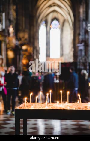 Bougies dans l'église avec fond flou de la cathédrale Saint-Étienne à Vienne, Autriche, service catholique Saint Banque D'Images