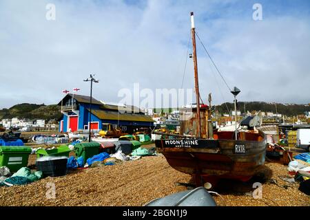 Bateau de pêche appelé Moonshine sur la plage de Slade shingle, station de sauvetage en arrière-plan, Hastings, East Sussex, Angleterre, Royaume-Uni Banque D'Images