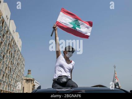 Beyrouth, Liban. 22 avril 2020. Les manifestants portant des masques de protection montrent que sur les voitures qui agissent le drapeau national libanais sur la place Martyr de Beyrouth, les manifestants protestent contre la détérioration du niveau de vie, notamment la hausse des prix et le chômage, ont exacerbé les mesures de verrouillage sévères pour lutter contre la propagation du coronavirus covid-19. Crédit: amer ghazzal/Alay Live News Banque D'Images