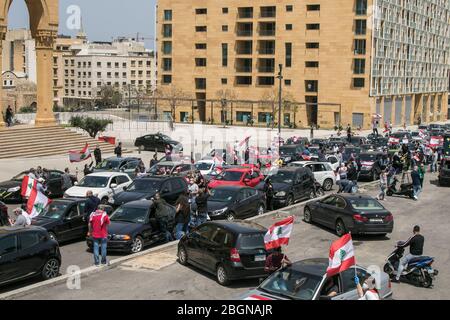 Beyrouth, Liban. 22 avril 2020. Les manifestants portant des masques de protection se présentent sur la place Martyr à Beyrouth lorsqu'ils prennent part à un convoi de voitures avec des conducteurs qui se marient avec leurs cornes, Agitant le drapeau national libanais et se penchant sur les vitres de la voiture pour protester contre la détérioration du niveau de vie, y compris la hausse des prix et du chômage exacerbés depuis que le gouvernement a imposé des mesures de verrouillage sévères pour lutter contre la propagation du coronavirus covid-19. Crédit: amer ghazzal/Alay Live News Banque D'Images