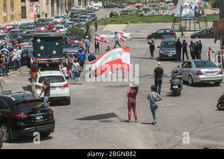 Beyrouth, Liban. 22 avril 2020. Les manifestants portant des masques de protection se présentent sur la place Martyr à Beyrouth lorsqu'ils prennent part à un convoi de voitures avec des conducteurs qui se marient avec leurs cornes, Agitant le drapeau national libanais et se penchant sur les vitres de la voiture pour protester contre la détérioration du niveau de vie, y compris la hausse des prix et du chômage exacerbés depuis que le gouvernement a imposé des mesures de verrouillage sévères pour lutter contre la propagation du coronavirus covid-19. Crédit: amer ghazzal/Alay Live News Banque D'Images