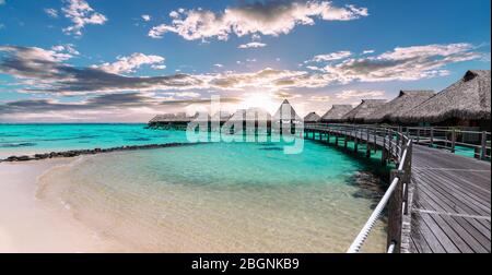 Vue panoramique panoramique panoramique panoramique sur les bungalows de luxe sur la plage et le lagon au coucher du soleil à Moorea, Polynésie française. Banque D'Images