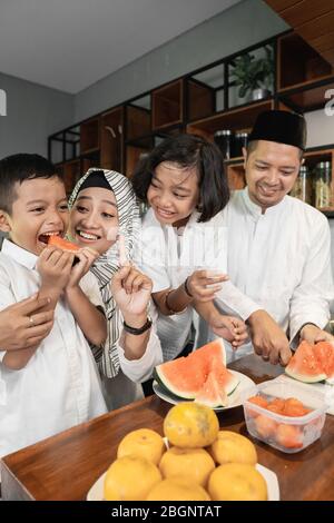 la mère avertira son enfant de cesser de manger le melon d'eau avant le moment de briser le rapide Banque D'Images