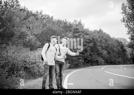 Geste de randonnée. Commencez une grande aventure dans votre vie avec la randonnée pédestre. Compagnie amis voyageurs qui déchire à la route nature fond. Voyageurs en route. Des amis qui voyagent avec des hitchhikers. Banque D'Images