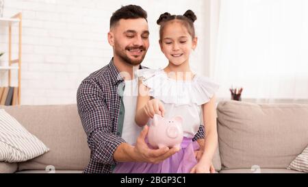 Papa a enseigné à sa fille pour économiser de l'argent à la maison Banque D'Images