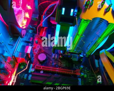 Refroidissement moderne de l'air de l'ordinateur avec ventilateurs à rétroéclairage à LED multicolores, radiateurs de refroidissement, câbles, cartes, gros plan, macro. Banque D'Images