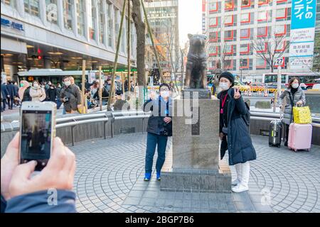 Famille japonaise prenant une photo avec statue de chien à Shibuya tout en portant un masque pour protéger l'infection de Covid-19. Tokyo, Japon 8 février 2020 Banque D'Images