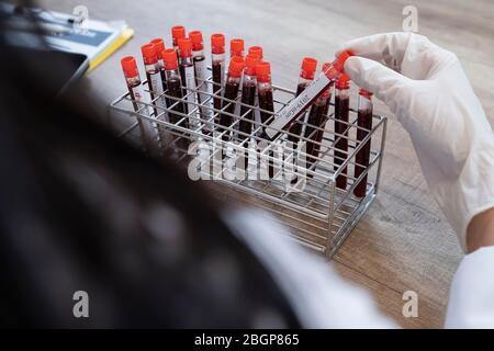 Gros plan sur les mains de médecins asiatiques. Il prend du sang de coronavirus du patient dans le tube à essai à Lap. Banque D'Images