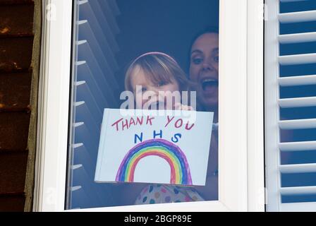 Brighton UK 22 avril 2020 - une jeune fille et sa mère bâton A Merci NHS Rainbow peinture et message à leur maison Woodingdean près de Brighton pendant le verrouillage dans la crise pandémique Coronavirus COVID-19 . Crédit: Simon Dack / Alay Live News Banque D'Images