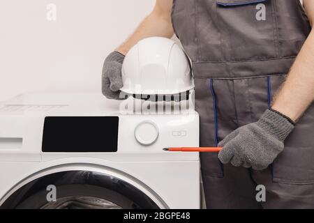 Plombier réparant le lave-linge, homme en service résolvant le problème Banque D'Images